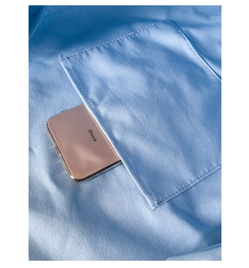 Détail d'un sac cabas en toile avec une poche avant contenant un smartphone