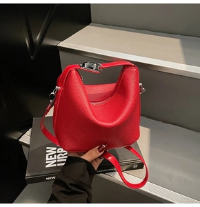 Detail of red litchi grain leather bag showing the silver metal buckle and strap