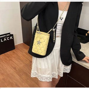 Detailed shot of yellow quilted crossbody phone bag with rhinestone star and chain strap