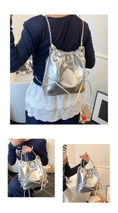 Detailed macro view of silver metallic drawstring bucket bag with decorative bows