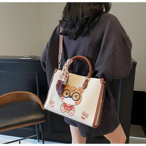 Detail view of large tote bag with cartoon bear print and brown leopard silk scarf