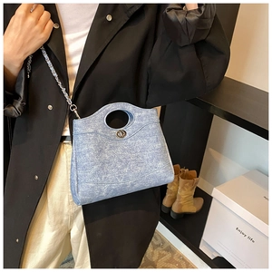 Vue détaillée du sac seau en denim matelassé bleu clair avec fermoir rotatif argenté