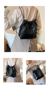Detail of black glossy leather drawstring backpack with bow accents and chain straps
