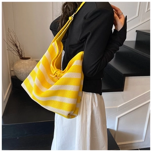 Macro shot of large striped woven tote bag featuring yellow and beige mesh texture
