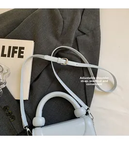 Détail de la bandoulière réglable sur le sac à main en cuir ciré bleu clair tendance