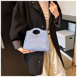 Détail du sac seau matelassé bleu clair avec fermoir argenté et bandoulière chaîne
