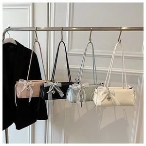 Détails de quatre sacs à bandoulière avec nœuds en dentelle, perles et breloques en cœur colorés