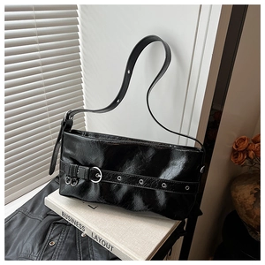 Detailed macro of black pleated leather shoulder bag with silver eyelet belt buckle