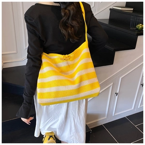 Detail of yellow and white striped woven tote bag with wooden toggle closure and net texture