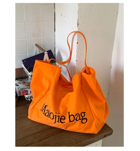 Détail du grand sac cabas en toile orange vif avec imprimé de lettres artistiques