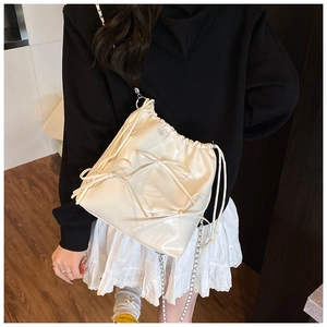 Detail of cream drawstring backpack with glossy finish and sweet ribbon bows decoration