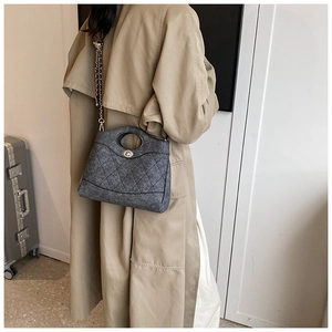 Gros plan du sac seau matelassé gris avec texture en laine et détails de bandoulière
