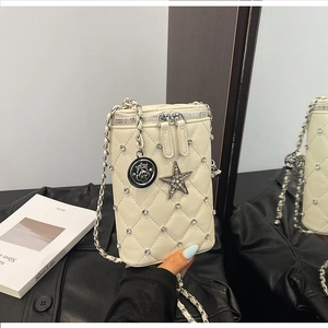 Detail of off-white quilted mini bag with crystal studs and silver chain strap