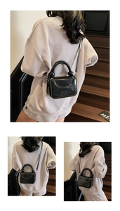 Vue détaillée du sac à bandoulière en cuir ciré noir avec poignée ronde chic décor