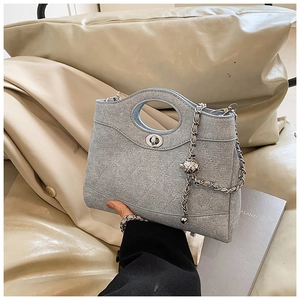 Détail du sac seau matelassé bleu clair avec poignée ronde et bandoulière chaîne