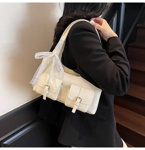 Dettaglio della borsa tote bianco crema con fibbie argentate e fiocco in pizzo raffinato