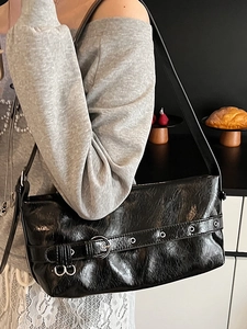 Minimalist black glossy shoulder bag with silver buckle and eyelet strap for women