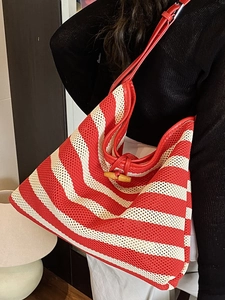 Women's woven tote bag with red and white stripes and a wooden horn toggle closure