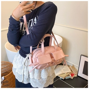 Détail du sac en cuir verni rose avec poches à nœuds et longue bandoulière réglable
