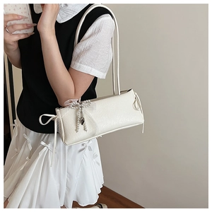 Détail du sac blanc sous l'aisselle avec nœud en perles, dentelle et rubans élégants
