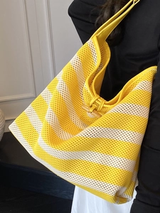 Casual striped knit hobo tote bag in yellow and cream with wooden horn button closure