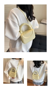 Détail d'un sac à main minimaliste jaune crème avec poignée ronde et bandoulière fine