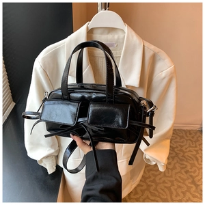 Vue détaillée du sac en cuir PU noir brillant avec rubans décoratifs et poches avant