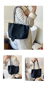 Detail showing high-quality black lychee texture leather on a stylish large tote bag