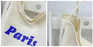 Detalle del bolso de lona blanca con estampado Paris azul y etiqueta tejida negra