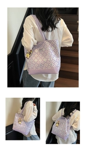 Detail view of purple geometric pattern tote bag featuring leather base and doll charm accessory