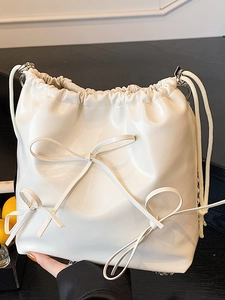 Chic cream white drawstring bucket bag with decorative 3D bows and silver chain strap