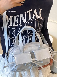 Sac baguette en cuir verni bleu clair avec détail nœud et deux poches avant