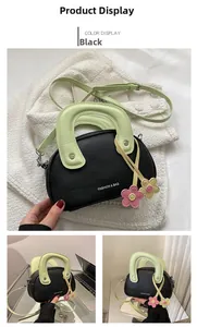 Vue détaillée du mini sac noir avec sangle vert menthe et pendentifs fleurs stylés