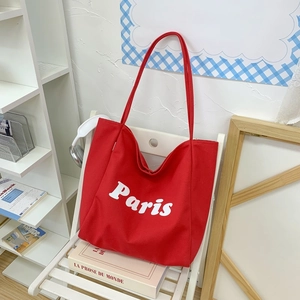 Detalle del bolso tote de lona roja con estampado blanco de París y correas anchas