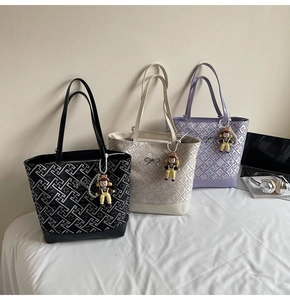Three large tote bags with geometric texture and cute charms in a lifestyle setting