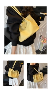 Detail of light yellow lychee pattern leather tote bag with elegant shoulder straps and buckle