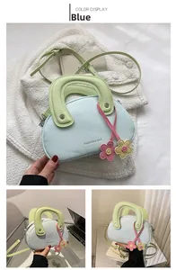 Détail du sac selle bleu avec poignée verte et breloques florales en décor quotidien