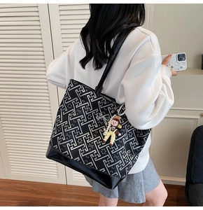 Detail of geometric pattern tote bag with polished base and cute cartoon pendant