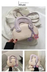Vue détaillée du sac bandoulière kaki avec poignée lilas et accessoire de charme floral