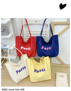Vista detallada de los bolsos tote grandes de lona en cuatro colores con logo Paris