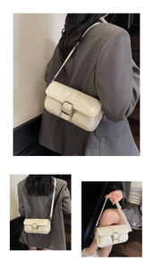 Detailed views of creamy white shoulder bag featuring a glossy finish and large silver buckle