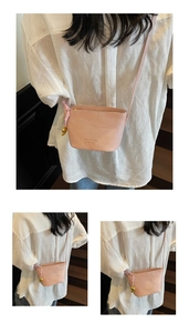 Sac seau rose motif crocodile avec charm cœur doré sur un escalier en bois