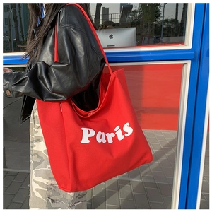 Detalle lateral del bolso tote grande de lona roja con estampado Paris y gran capacidad