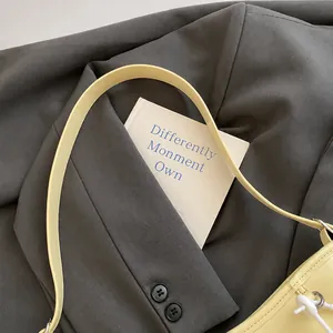 Detail shot of a soft cream yellow tote bag showing smooth leather texture and refined strap