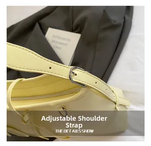 Detail view of adjustable strap with silver buckle on light yellow soft leather bag