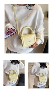 Détail du sac à main en cuir crème avec poignée ronde et gravure logo en métal