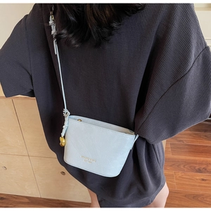 Détail du petit sac seau bleu clair à motif crocodile avec pendentif coeur doré