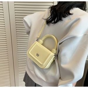 Détail arrière d'un mini sac à main carré jaune clair avec bandoulière et logo en métal