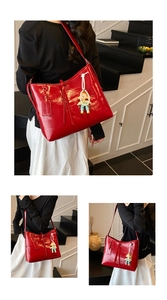 Detail of red glossy patent leather tote bag with woven charm and mirror-like reflection