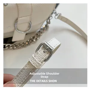 Détail de la bandoulière réglable avec boucle argentée sur sac en cuir grainé blanc